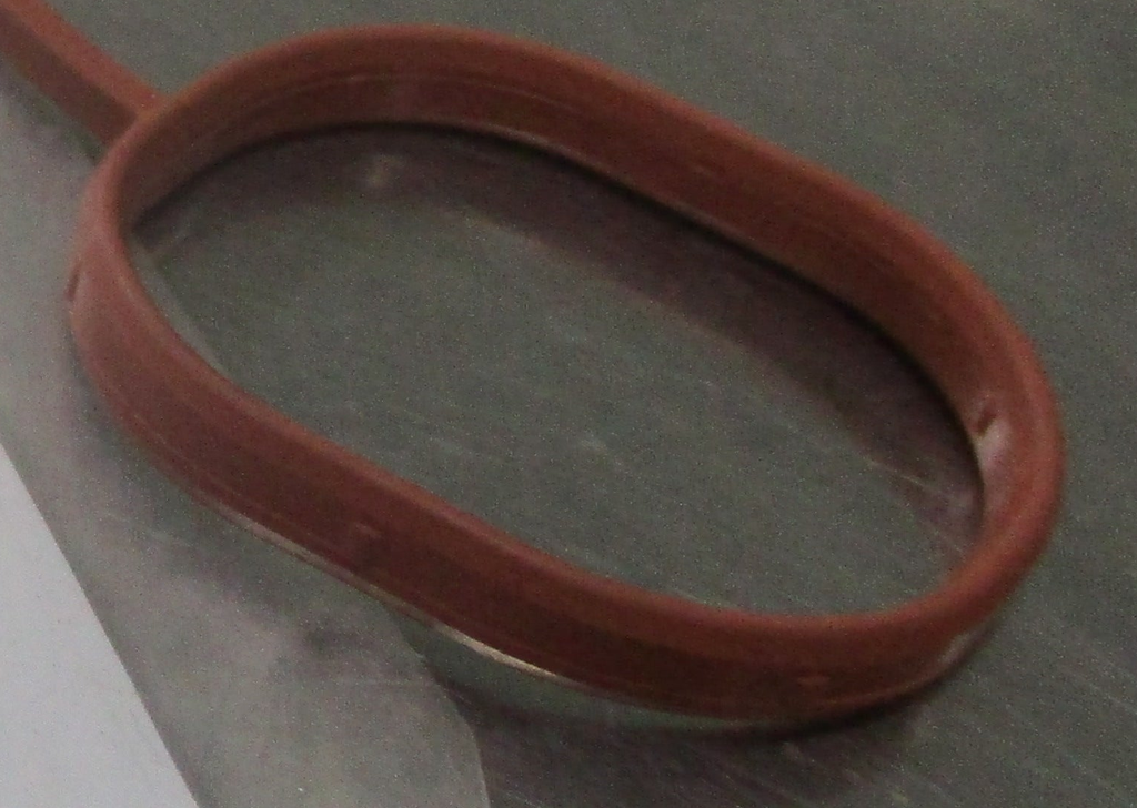 Reference photograph - intake manifold gasket 28411-2B600 - same-photo opposite-end port and raised-lip detail